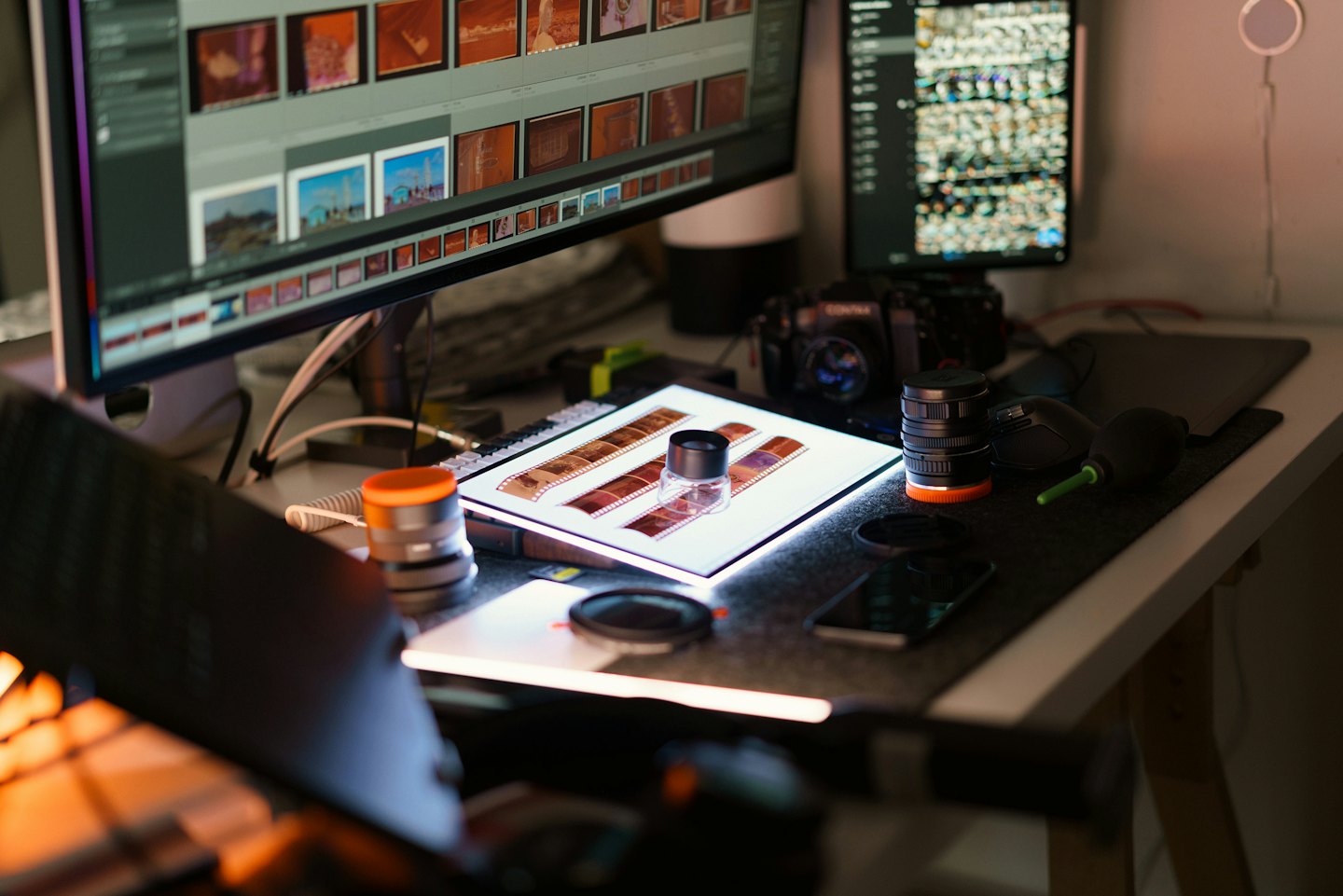Photography equipment and editing monitors sit on a desk.